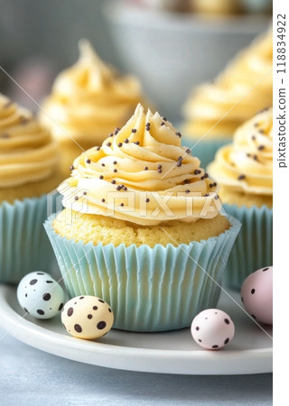 Deliciously decorated vanilla cupcakes with pastel toppings and speckled candy eggs on a plate 118834922