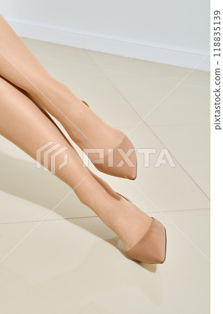Front view of female legs in beige stilettos Front view of female legs in beige stilettos 118835139