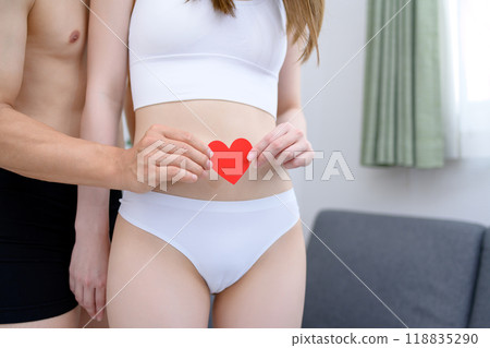 Couple supporting the woman's belly with care, couple holding a heart together, couple, pregnancy, infertility treatment 118835290