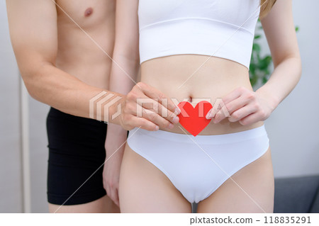 Couple supporting the woman's belly with care, couple holding a heart together, couple, pregnancy, infertility treatment 118835291