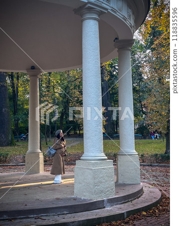 Person standing under gazebo in autumn park 118835596