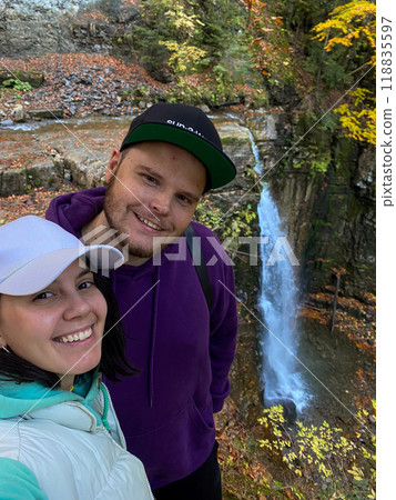 Couple Enjoying Nature by a Waterfall Couple Enjoying Nature by a Waterfall 118835597