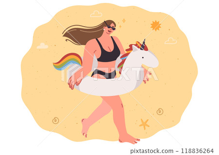 Woman with inflatable unicorn ring walks along beach, enjoying vacation on tropical island Woman with inflatable unicorn ring walks along beach, enjoying vacation on tropical island 118836264