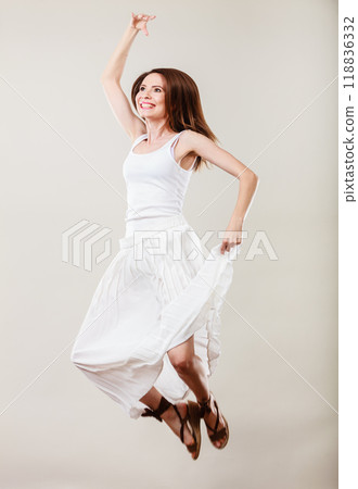 Woman in summer white dress jumping Woman in summer white dress jumping 118836332