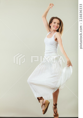 Woman in summer white dress jumping Woman in summer white dress jumping 118836333