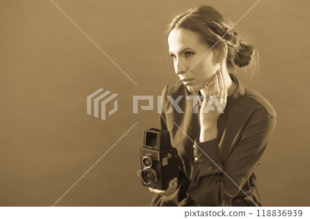 Woman taking picture with old camera Woman taking picture with old camera 118836939