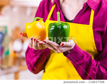 Woman holding two bell peppers Woman holding two bell peppers 118837396
