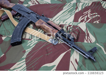 AK assault rifle on camo uniform background 118838123