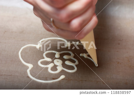 Woman makes a pattern of dough on a baking sheet. For the preparation of biscuit roll with spinach and mint. Stuffed with strawberries. Ingredients for cooking. 118838597