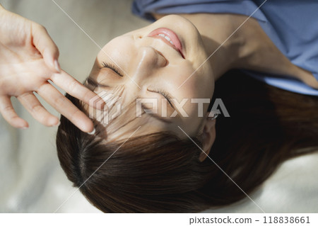 Woman lying on her back in a blue dress Woman lying on her back in a blue dress 118838661
