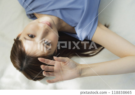 Woman lying on her back in a blue dress 118838665