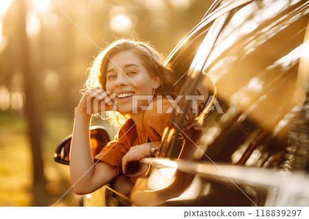 Happy woman on summer trip, travels leaning out of the car window. Active lifestyle. Travel concept. Happy woman on summer trip, travels leaning out of the car window. Active lifestyle. Travel concept. 118839297