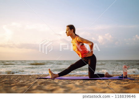Yoga in the morning. Young woman in sportswear doing fitness exercise on beach. Healthy lifestyle. Yoga in the morning. Young woman in sportswear doing fitness exercise on beach. Healthy lifestyle. 118839646