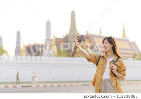 Traveler asian woman in her 30s explores the Grand Palace with a local guide. Uncover hidden gems and immerse yourself in Thai culture with her adventure. Traveler asian woman in her 30s explores the Grand Palace with a local guide. Uncover hidden gems and immerse yourself in Thai culture with her adventure. 118839865