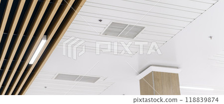 Ceiling mounted cassette type air conditioner and modern lamp light on a white ceiling. duct air conditioner for office or home 118839874