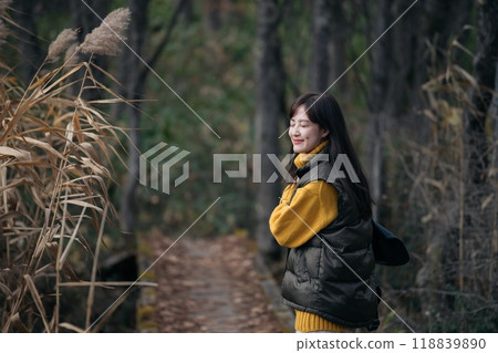 Solo female hiker finds peace and beauty on a fall foliage trail in Japan. 118839890