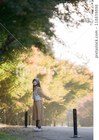 Seasonal delight, Asian woman in a casual dress enjoys fall in Japan. Elegant portrait with colorful maple foliage, capturing her cheerful smile and the beauty of the changing season. Seasonal delight, Asian woman in a casual dress enjoys fall in Japan. Elegant portrait with colorful maple foliage, capturing her cheerful smile and the beauty of the changing season. 118839898