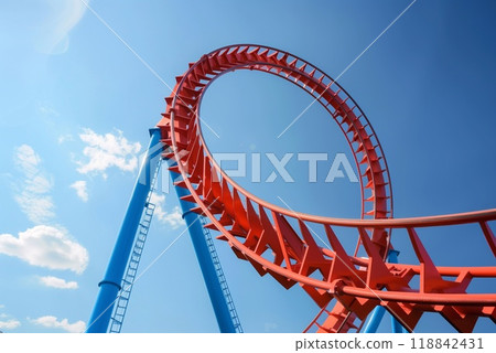 A roller coaster loop rises high into the sky, showcasing its vibrant colors under the bright sun, providing excitement for thrill seekers 118842431