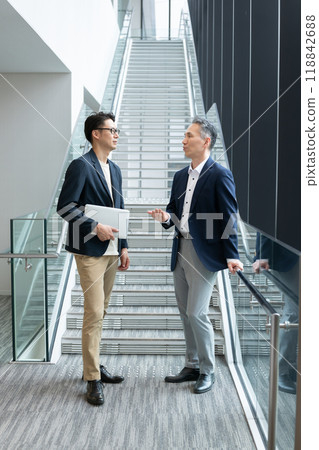 Businessmen standing and talking in the hallway 118842688