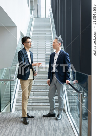 Businessmen standing and talking in the hallway Businessmen standing and talking in the hallway 118842689