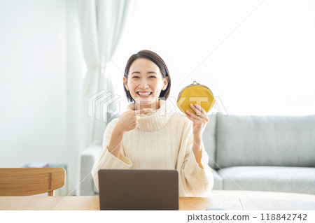 Woman holding a wallet, smiling, pointing Woman holding a wallet, smiling, pointing 118842742