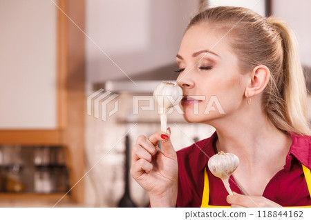 Woman holding and smelling garlic Woman holding and smelling garlic 118844162