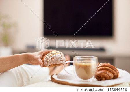 female hand holding fresh french croissants and glass of coffee for breakfast in bed in the morning, tasty breakfast female hand holding fresh french croissants and glass of coffee for breakfast in bed in the morning, tasty breakfast 118844718