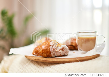 Delicious fresh french croissants and glass of coffee on wooden tray for breakfast in bed in the morning, tasty breakfast Delicious fresh french croissants and glass of coffee on wooden tray for breakfast in bed in the morning, tasty breakfast 118844719