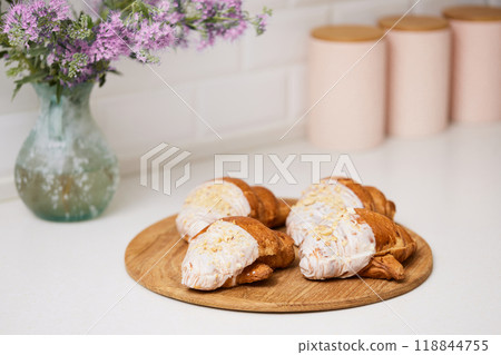Delicious fresh croissants on wooden tray on white table, closeup 118844755