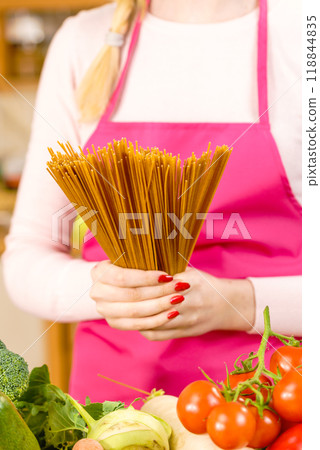 Woman holding long pasta Woman holding long pasta 118844835