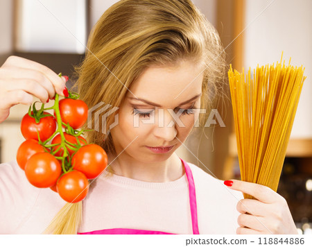 Woman holding pasta and tomatoes 118844886