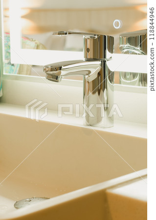 A shiny silver metal faucet on the sink. A shiny silver metal faucet on the sink. 118844946