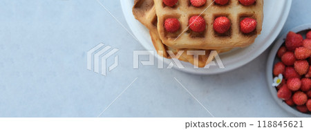 Banner. Belgian or Viennese waffles with strawberries on minimalistic concrete grey background. delicious sweet dish, copy space for text 118845621