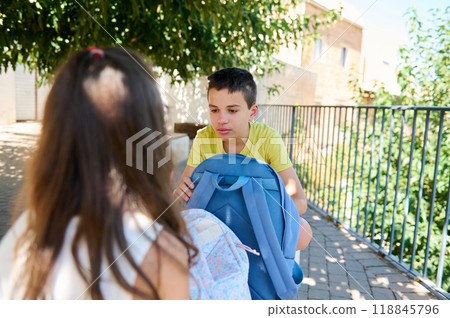 Children talking on walkway with backpack under sunny sky 118845796