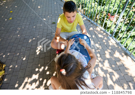 Children sitting in park engaged in playful activity Children sitting in park engaged in playful activity 118845798