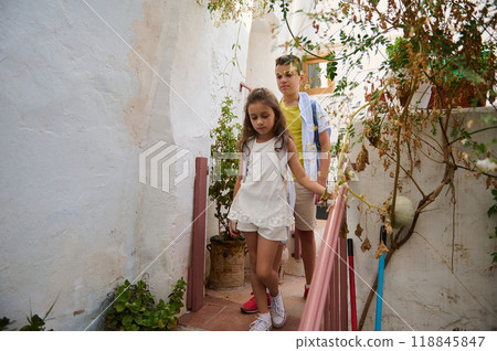 Children exploring a rustic garden with lush greenery Children exploring a rustic garden with lush greenery 118845847