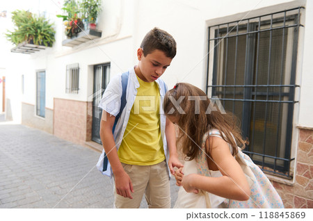 Two children interacting on a quiet street in summer 118845869