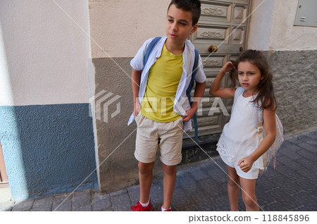 Children with backpacks standing outdoors on a sunny day 118845896