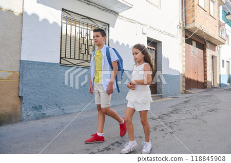 Brother and sister walking down a suburban street in summer attire Brother and sister walking down a suburban street in summer attire 118845908