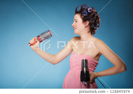 girl with curlers in hair holds hairdreyer girl with curlers in hair holds hairdreyer 118845974