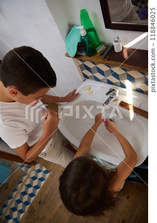 Children brushing teeth together in a bathroom setting 118846025