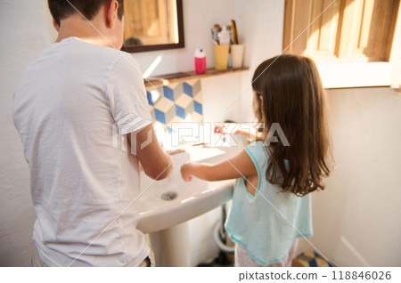 Children washing hands in bathroom with natural light 118846026