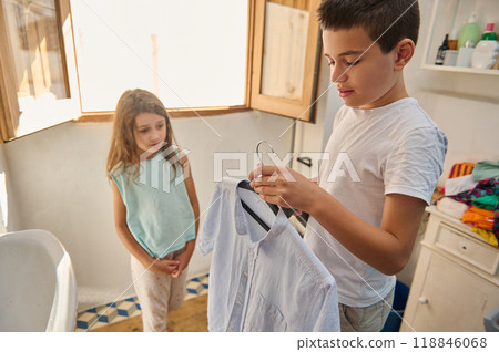 Brother and sister preparing clothes for the day in the bathroom Brother and sister preparing clothes for the day in the bathroom 118846068