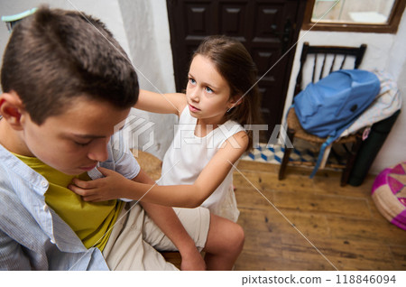 Concerned young girl checking on a sad boy indoors 118846094