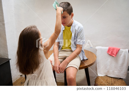 Sister caring for brother with a cool compress at home Sister caring for brother with a cool compress at home 118846103