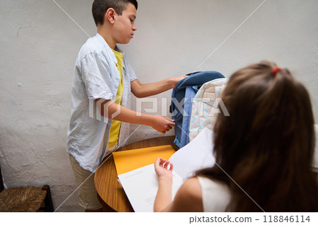 Children organizing school supplies into backpacks at home Children organizing school supplies into backpacks at home 118846114