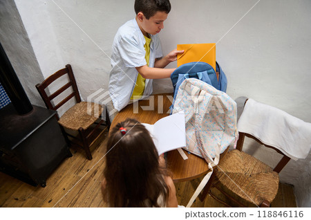 Children organizing school supplies at home table Children organizing school supplies at home table 118846116