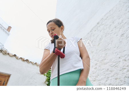 Woman practicing with resistance band in outdoor setting for exercise and fitness routine, showcasing healthy lifestyle Woman practicing with resistance band in outdoor setting for exercise and fitness routine, showcasing healthy lifestyle 118846249