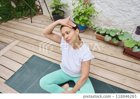 Woman practicing yoga meditation in serene outdoor garden, focusing on mindfulness and relaxation. Peaceful exercise routine for mental and physical health in natural setting. Woman practicing yoga meditation in serene outdoor garden, focusing on mindfulness and relaxation. Peaceful exercise routine for mental and physical health in natural setting. 118846265