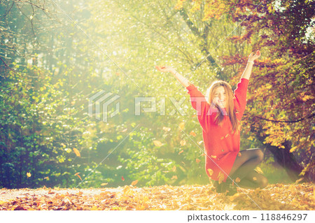 Playful woman outdoors playing with leaves. Playful woman outdoors playing with leaves. 118846297